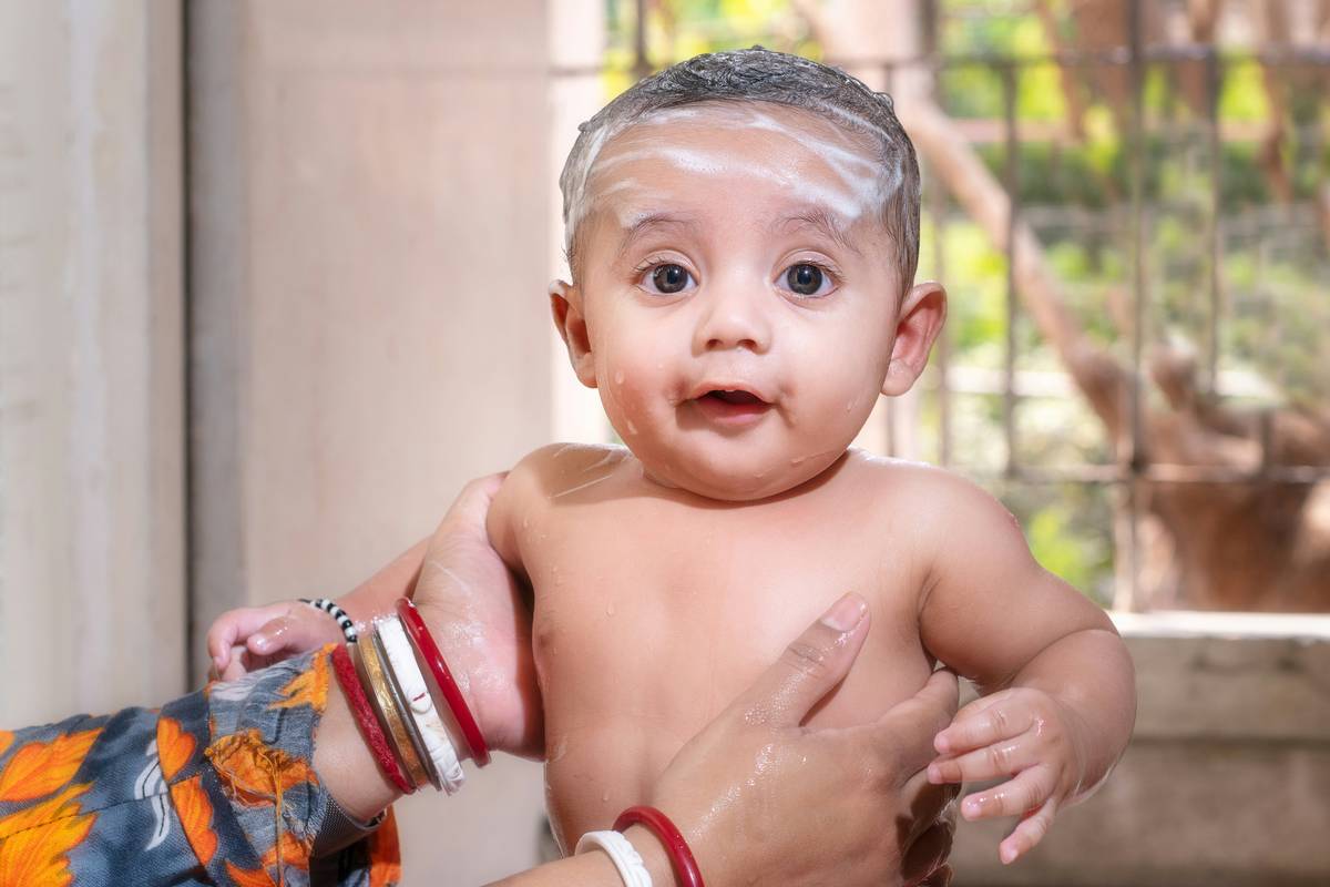 mother applying most gentle baby sunscreen on infant's face at beach