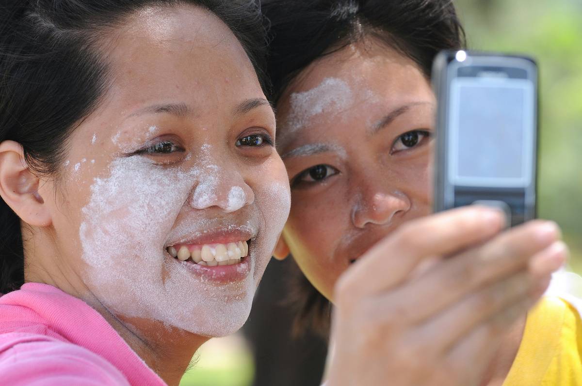 sunscreen application for kids on a toddler's face and arms at the beach